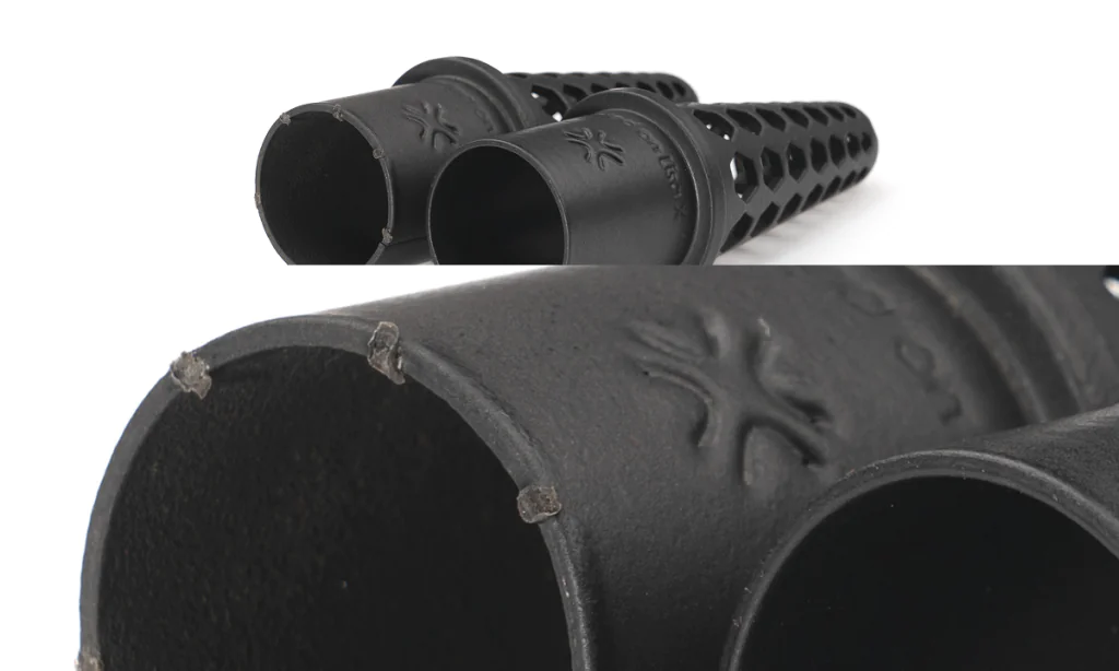 Two black SLS 3D-printed tubes with embossed Sinterit logo; close-up highlights chipped edges on one part caused by incorrect positioning during post-processing.