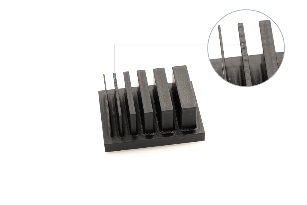 3D-printed test part with vertical fins of increasing thickness; close-up reveals post-processing deformation on the thinnest walls due to vapor smoothing.