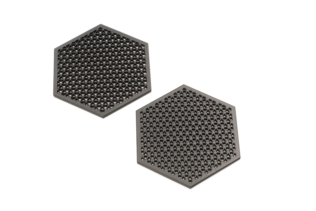 Two hexagonal 3D-printed mesh parts with different lattice densities, made with SLS and vapor smoothed, displayed on a white background.
